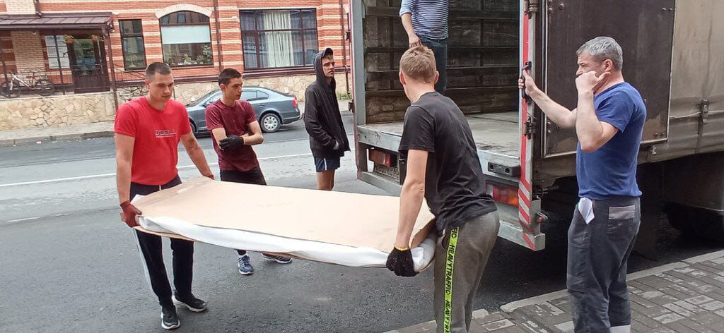 Грузчики переносят матрас